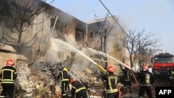 A handout picture provided by the news agency TASNIM on February 21, 2022 shows firefighters putting out a blaze at the crash site of a fighter jet in a residential area of the northwestern city of Tabriz.