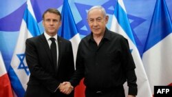 Perdana Menteri Israel Benjamin Netanyahu (kanan) menyambut Presiden Prancis Emmanuel Macron sebelum pertemuan di Yerusalem pada 24 Oktober 2023. (Foto: AFP)