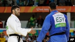 Egypt's Islam El Shehaby, blue, declines to shake hands with Israel's Or Sasson, white, after losing during the men's over 100-kg judo competition at the 2016 Summer Olympics in Rio de Janeiro, Brazil, Aug. 12, 2016.