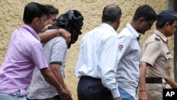 Police officials escort an accused, head covered with black cloth, in the gang rape of a young photojournalist in the Indian financial hub of Mumbai, Aug. 24, 2013.