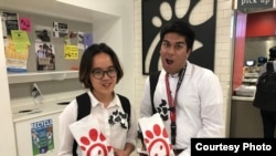 Asian Americans Advancing Justice interns Dieu Linh Nguyen, left, and Tauheed Islam got free sandwiches July 8 at a Chick-fil-A cow appreciation event. (A. Peng)