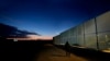 FILE - A man walks by the fence at the Pournara migrant reception center in Kokkinotrimithia outside of capital Nicosia, Cyprus, Jan. 24, 2024. 