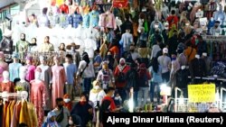 Para pengunjung tetap menggunakan masker saat berbelanja menjelang hari raya Idul Fitri di Pasar Tanah Abang di Jakarta Pusat pada 3 Mei 2021. (Foto: Reuters/Ajeng Dinar Ulfiana)