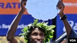 Geoffrey Mutai, dari Kenya, mengangkat penghargaannya setelah memenangkan marathon New York City, Minggu (6/11).