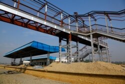 FILE - Nepalese construction laborers work at the terminal train station at Kurtha near Janakpur, Nepal from where a new rail line connects to Jay Nagar in the Indian state of Bihar.