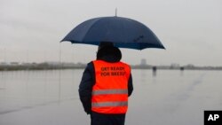 A spokesperson wears a safety vest during a press tour of an overflow parking lot for trucks after the Brexit transition period, in Hook of Holland, near Rotterdam, Netherlands, Dec. 21, 2020.