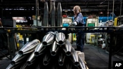 FILE - A steel worker moves a 155 mm artillery projectile during its manufacturing process at the Scranton Army Ammunition Plant in Scranton, Pennsylvania, April 13, 2023.