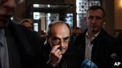 FILE - French Cardinal Philippe Barbarin, center, arrives at the Lyon courtroom, central France, for his appeal trial in Lyon, Nov.28, 2019. 