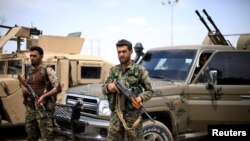 FILE - Fighters of the Syrian Democratic Forces are seen in Deir el-Zour, Syria, May 1, 2018.