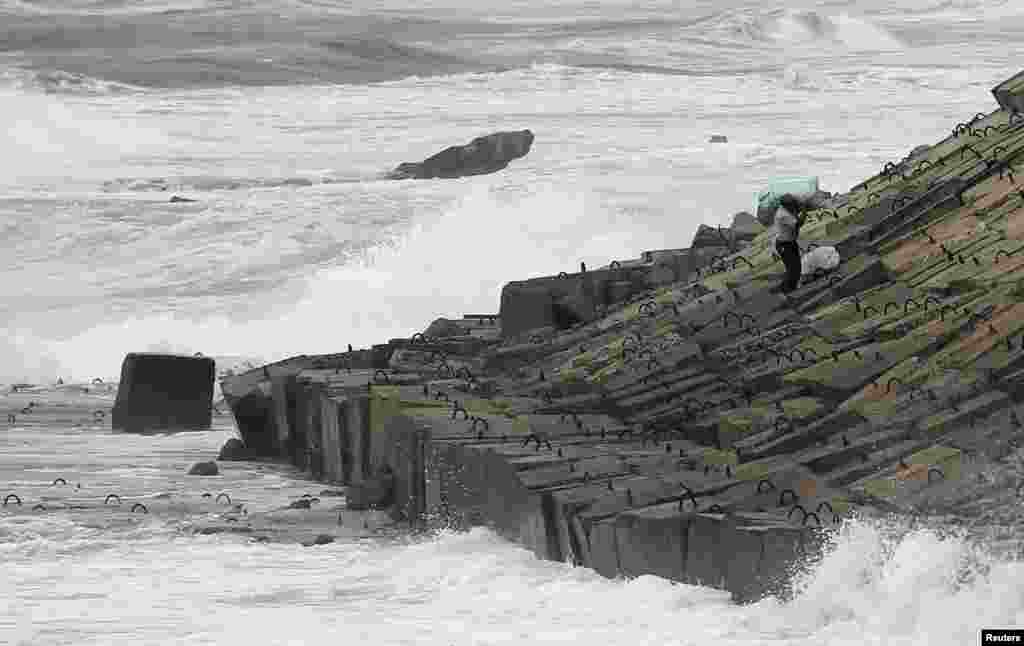 A man carries bags along the shoreline near the Citadel of Qaitbay on the last day of Eid al-Adha in the Mediterranean city of Alexandria, 230 km (143 miles) north of Cairo, Egypt, Oct. 18, 2013.