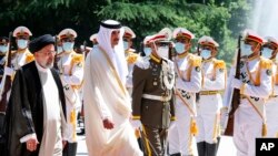 Emir Qatar Sheikh Tamim bin Hamad Al Thani, kedua kiri, saatdisambut Presiden Ebrahim Raisi, kiri, dalam upacara kedatangan resmi di Istana Saadabad di Teheran, Iran, Kamis, 12 Mei 2022. (Foto: : melalui AP)