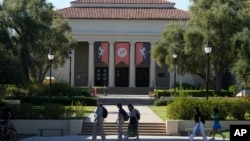 FILE - Students walk past the Thorne Hall at Occidental College campus in Los Angeles, July 27, 2023.