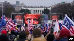 FILE - President Donald Trump, seen on jumbotrons, speaks at a rally of his supporters in Washington, Jan. 6, 2021, just prior to hundreds of them storming the U.S. Capitol.