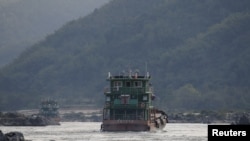 FILE - Chinese cargo ships sail on the Mekong River near the Golden Triangle at the border between Laos, Myanmar and Thailand March 1, 2016.
