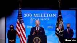 U.S. President Joe Biden is flanked by Vice President Kamala Harris and White House COVID-19 Response Coordinator Jeff Zients as he speaks about the status of coronavirus disease (COVID-19) vaccinations and his administration's ongoing pandemic response.