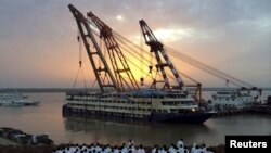 Para petugas berdiri di tepi sungai saat kapal pesiar "Eastern Star" yang terbalik berhasil ditarik dari sungai Yangtze di Jianli, provinsi Hubei, China (5/6).