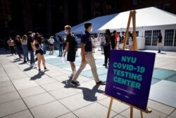 FILE - Students wait in line at a testing site for the COVID-19 set up for returning students, faculty and staff on the main campus of New York University (NYU) in Manhattan in New York City, Aug. 18, 2020.