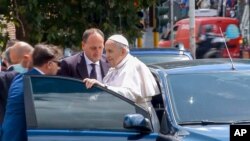 Pope Francis stops to greet the police that escorted him before entering the Vatican after leaving the hospital 10 days after undergoing planned surgery to remove half his colon, July 14, 2021. 