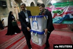 Poll workers carry ballot boxes after voting in parliamentary elections ended, in Tehran, Iran, Feb. 22, 2020. (via Wana News Agency)