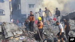 Palestinos buscan sobrevivientes entre los escombros dejados por los bombardeos israelies en la franja de Gaza el 17 de octubre de 2023; el número de víctimas fatales entre civiles ha subido exponencialmente. [AP]