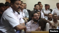 Bạn bè của các nhân viên cơ quan bất vụ lợi bị kết án phản ứng tại tòa án ở Cairo.