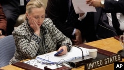 FILE - Then U.S. secretary of state Hillary Clinton checks her mobile phone after delivering an address to the Security Council at United Nations headquarters in New York, March 12, 2012.