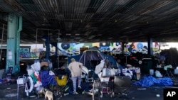 Desamparados recogen sus pertenencias antes del cierre de un campamento de desamparados en San Francisco, California, el 29 de agosto de 2023.