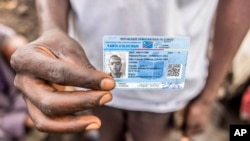 FILE - Elisha Manishimwe holds his voter's card in the Kanyaruchinya displaced camp outside Goma, eastern Democratic Republic of the Congo, Saturday, Dec. 9, 2023. 