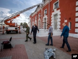 Roman Starovoit, gubernur wilayah Kursk, kedua kanan, dan pejabat lainnya memeriksa lokasi stasiun kereta api setelah dugaan serangan pesawat tak berawak Ukraina di Kursk, Rusia. (Foto: melalui AP)