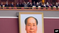 Chinese President Xi Jinping, center, waves above a large portrait of the late leader Mao Zedong during a ceremony to mark the 100th anniversary of the founding of the ruling Chinese Communist Party at Tiananmen Gate in Beijing Thursday, July 1, 2021.