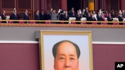 Chinese President Xi Jinping, center, waves above a large portrait of the late leader Mao Zedong during a ceremony to mark the 100th anniversary of the founding of the ruling Chinese Communist Party at Tiananmen Gate in Beijing, July 1, 2021. 