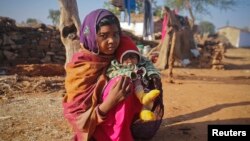 FILE - A 14-year-old girl sits with her four-month-old baby in a village in the northwestern India, January 21, 2013. The girl married her husband when she was 11 and he was 13. 