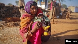 FILE - A 14-year-old girl sits with her four-month-old baby in a village in the northwestern India, January 21, 2013. The girl married her husband when she was 11 and he was 13.