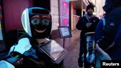 Para pengunjung Times Square berinteraksi dengan robot Promobot yang memberi informasi kepada masyarakat mengenai gejala virus korona dan bagaimana mencegah agar tidak menyebar, di New York, 10 Februari 2020. (Foto: Reuters)