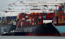 FILE -The Yang Ming shipping line container ship Ym Utmost is unloaded at the Port of Oakland on Monday, July 2, 2018, in Oakland, Calif.