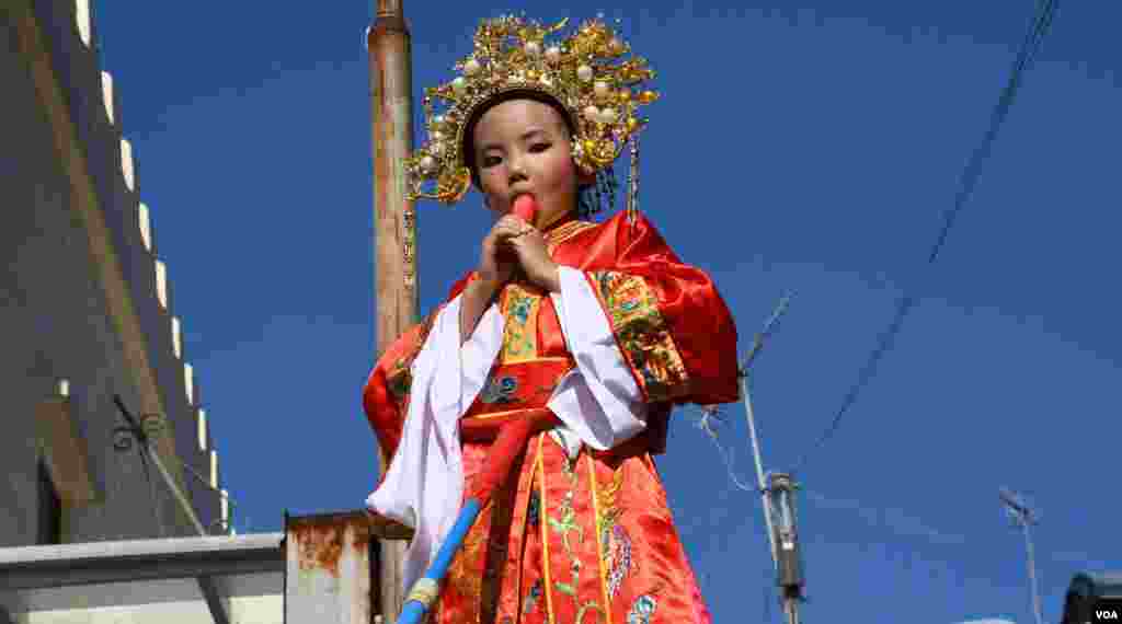 扮演古裝人物的小女孩在飄色巡遊時食雪條。(美國之音湯惠芸拍攝)