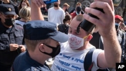 8月1日，俄罗斯圣彼德堡一参加支持哈巴罗夫斯克前州长的示威集会的抗议者与警察争辩。