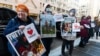 Retired United States Agency for International Development worker Julie Hanson Swanson, left, join supporters of USAID workers outside the USAID's Bureau of Humanitarian affairs office in Washington, Feb. 21, 2025.