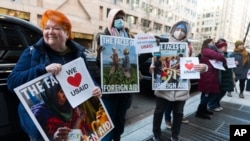 Retired United States Agency for International Development worker Julie Hanson Swanson, left, join supporters of USAID workers outside the USAID's Bureau of Humanitarian affairs office in Washington, Feb. 21, 2025.