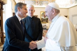 Pope Francis shakes hands with Secretary of State Antony Blinken, as they meet at the Vatican, June 28, 2021.