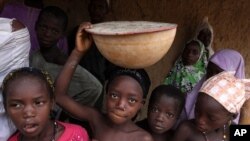 Children take shelter from the rain in front of a home in Yangalma village, where most of the children suffering from lead poisoning come from. (2010 File)