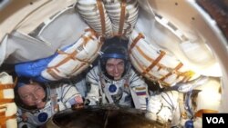 Tiga astronot tersenyum lebar sesaat setelah kapsul Soyuz mendarat dengan sukses di dekat kota Arkalyk, utara Kazakhstan (22/11). Dari kiri : Astronot Amerika Michael Fossum, Kosmonot Rusia Sergei Volkov dan Astronot Jepang Satoshi Furukawa.