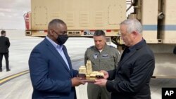 Menhan Israel Benny Gantz (kanan) memperlihatkan kepada Menhan AS Lloyd Austin (kiri), model sistem pertahanan rudal Iron Dome, yang digunakan oleh Israel dan Angkatan Darat AS, di Pangkalan Angkatan Udara Israel Nevatim, Senin, 12 April 2021 di Israel . (AP Photo/Robert Burns)