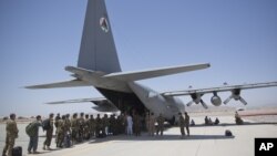 Soldados del Ejército Nacional afgano suben a un avión C-130 de EE.UU. en la Base Aérea Kandahar en Afganistán como parte de la asistencia que brinda el gobierno de Washington al de Kabul en el movimiento de tropas y equipos. Agosto 18, 2015.