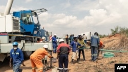 Rescue workers install a pump to drain water from a collapsed mineshaft at Ran Mine, in Bindura, Zimbabwe, Nov. 26, 2020.