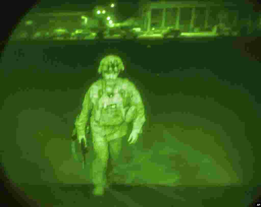 In this image made through a night vision scope and provided by the U.S. Army, Maj. Gen. Chris Donahue, commander of the U.S. Army 82nd Airborne Division, XVIII Airborne Corps, the last American service member to depart Afghanistan, boards a C-17 cargo plane at Hamid Karzai International Airport in Kabul, Aug. 30, 2021.