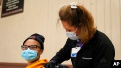 Isis Gardner, left, receives a dose of the Pfizer COVID-19 vaccine at the Banning Recreation Center in Wilmington, Calif., April 13, 2021. The site switched from the Johnson & Johnson COVID-19 vaccine to the Pfizer vaccine.