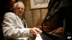 FILE - Irving Fields, New York City’s oldest cabaret singer and piano player, plays the piano during a 100th birthday celebration for him at Nino's Tuscany restaurant, Aug. 7, 2015.