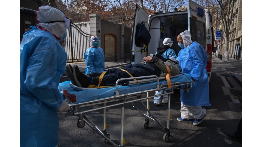 FILE - Medical staff in protective clothing transport a suspected coronavirus patient from an apartment in Wuhan, Hubei province, China, Jan. 30, 2020.