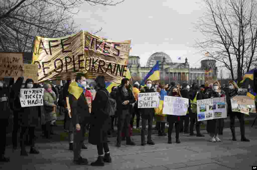 People protest against Russia and Russian President Putin after Russian troops have launched their anticipated attack on Ukraine, in front of the Reichstag building in Berlin, Germany, Feb. 24, 2022.